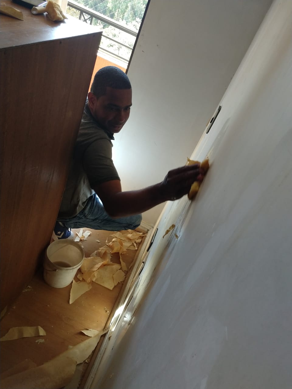 Me Sirve. Trabajador limpiando la pared.